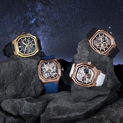 Four ornate watches on rocks with a starry night sky background